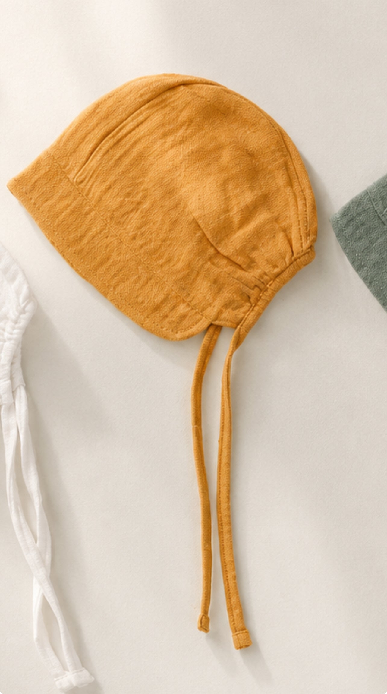 Bonnet in mussola con visiera