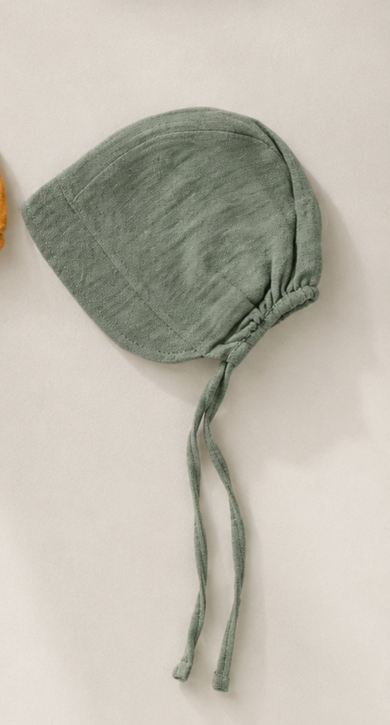 Bonnet in mussola con visiera