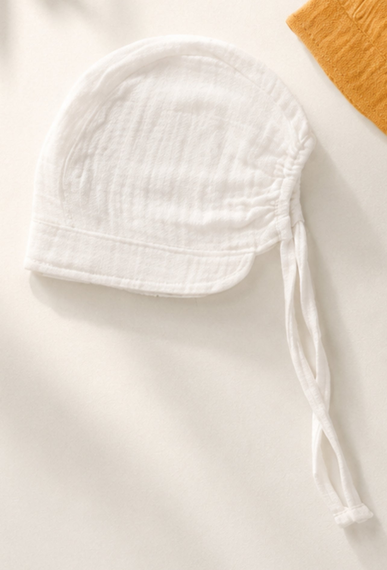 Bonnet in mussola con visiera